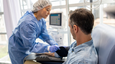 Krankenschwester mit sterilen Bekleidung überprüft die Vitalwerte eines Patienten. Krankenschwester mit sterilen Bekleidung überprüft die Vitalwerte eines Patienten.