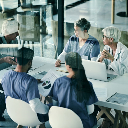 Eine Ärzteteam sitzt im Besprechungsraum um einen Tisch. Eine Ärzteteam sitzt im Besprechungsraum um einen Tisch.